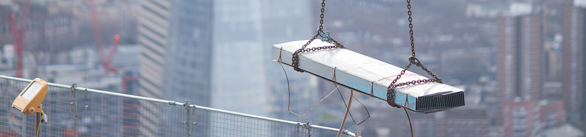 Steel beam guided into place by a man in London